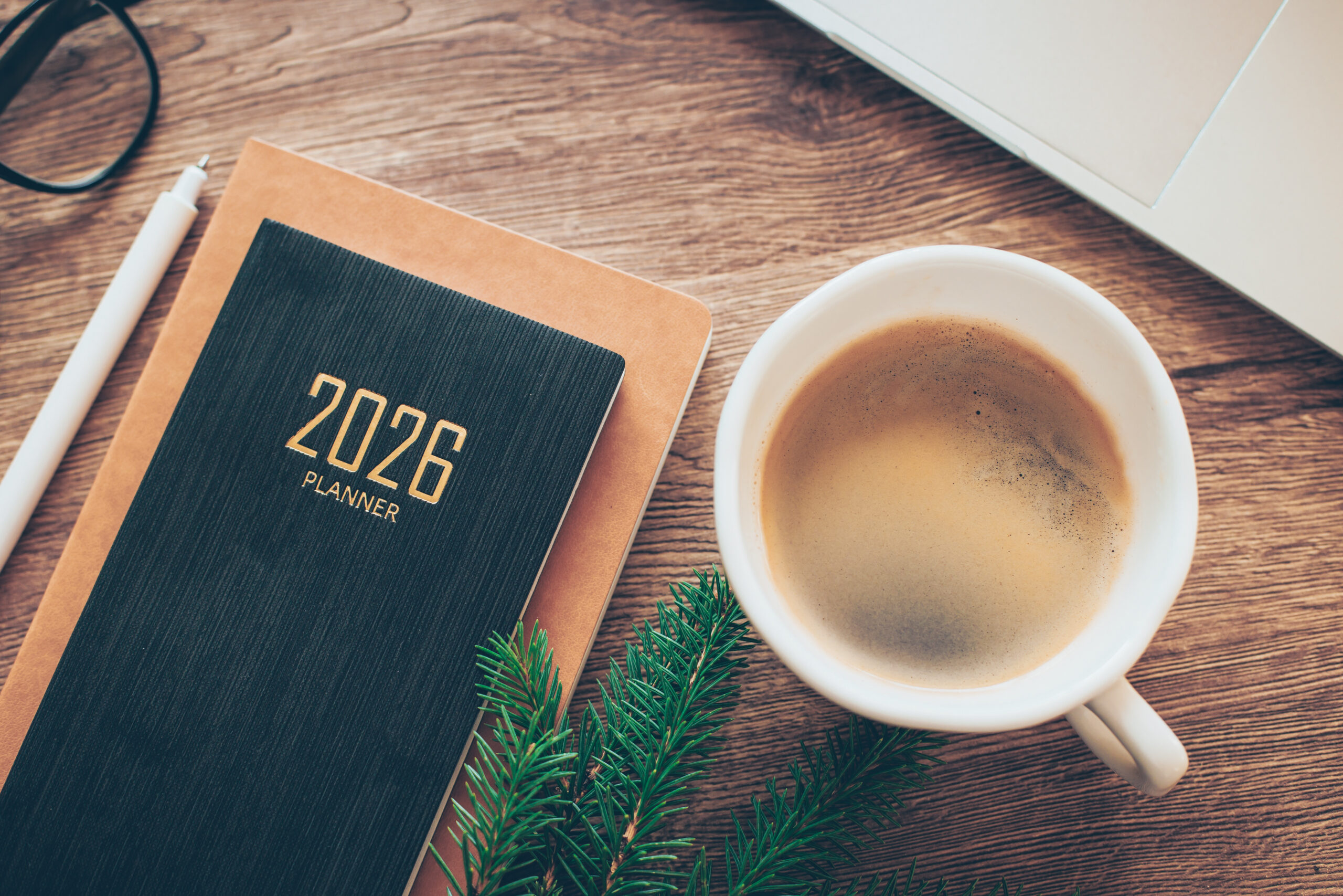 Cozy Workspace With 2026 Planner Coffee and Greenery on Wooden Desk